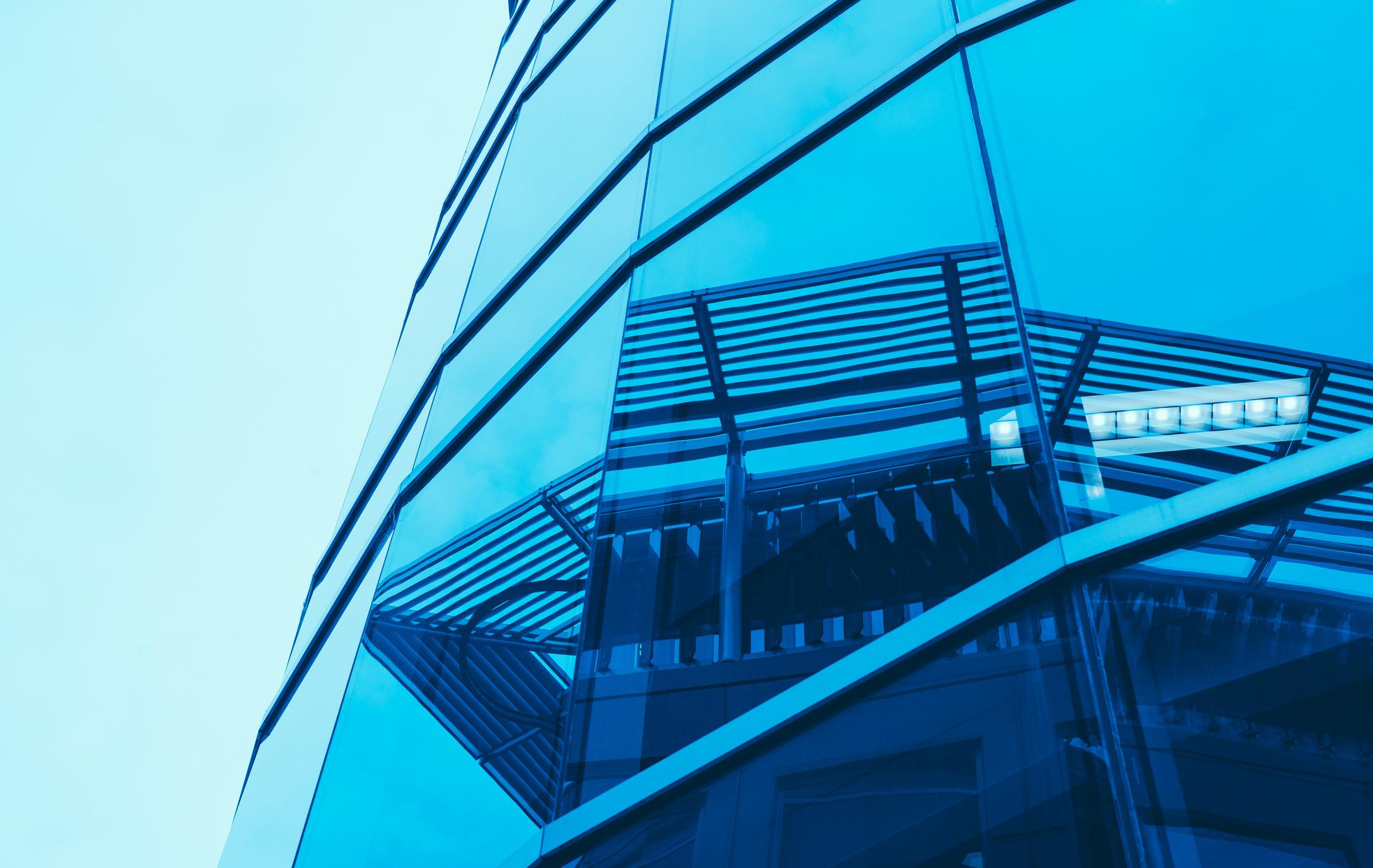 Other houses are reflected in a glazed building.