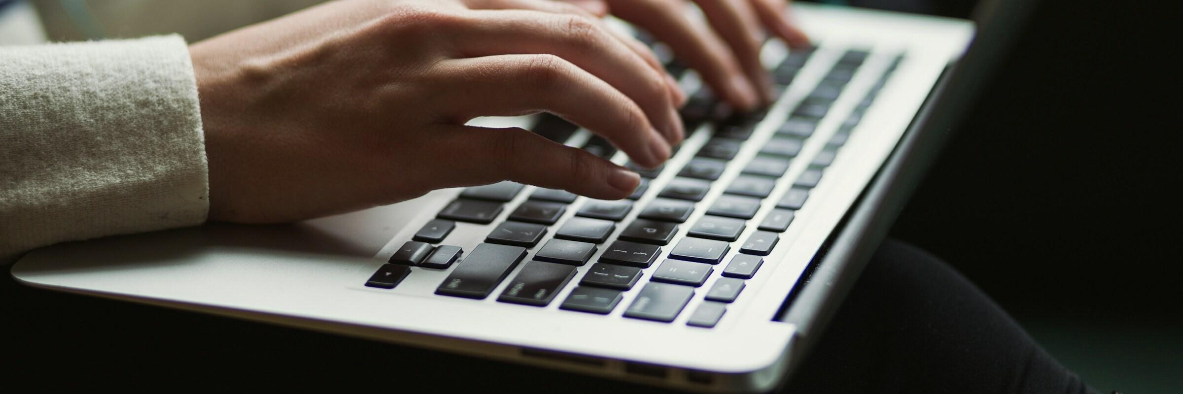 Finger auf Laptop Finger einer Person tippen auf einem Laptop