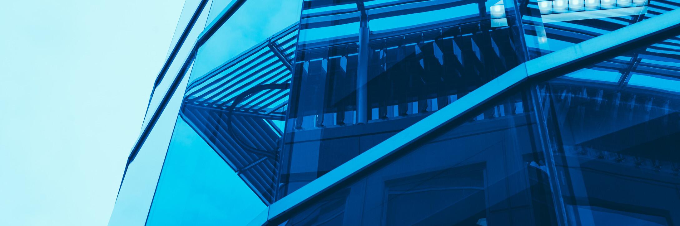 Spiegelung Häuser An einem verglasten Gebäude spiegeln sich weitere Häuser.