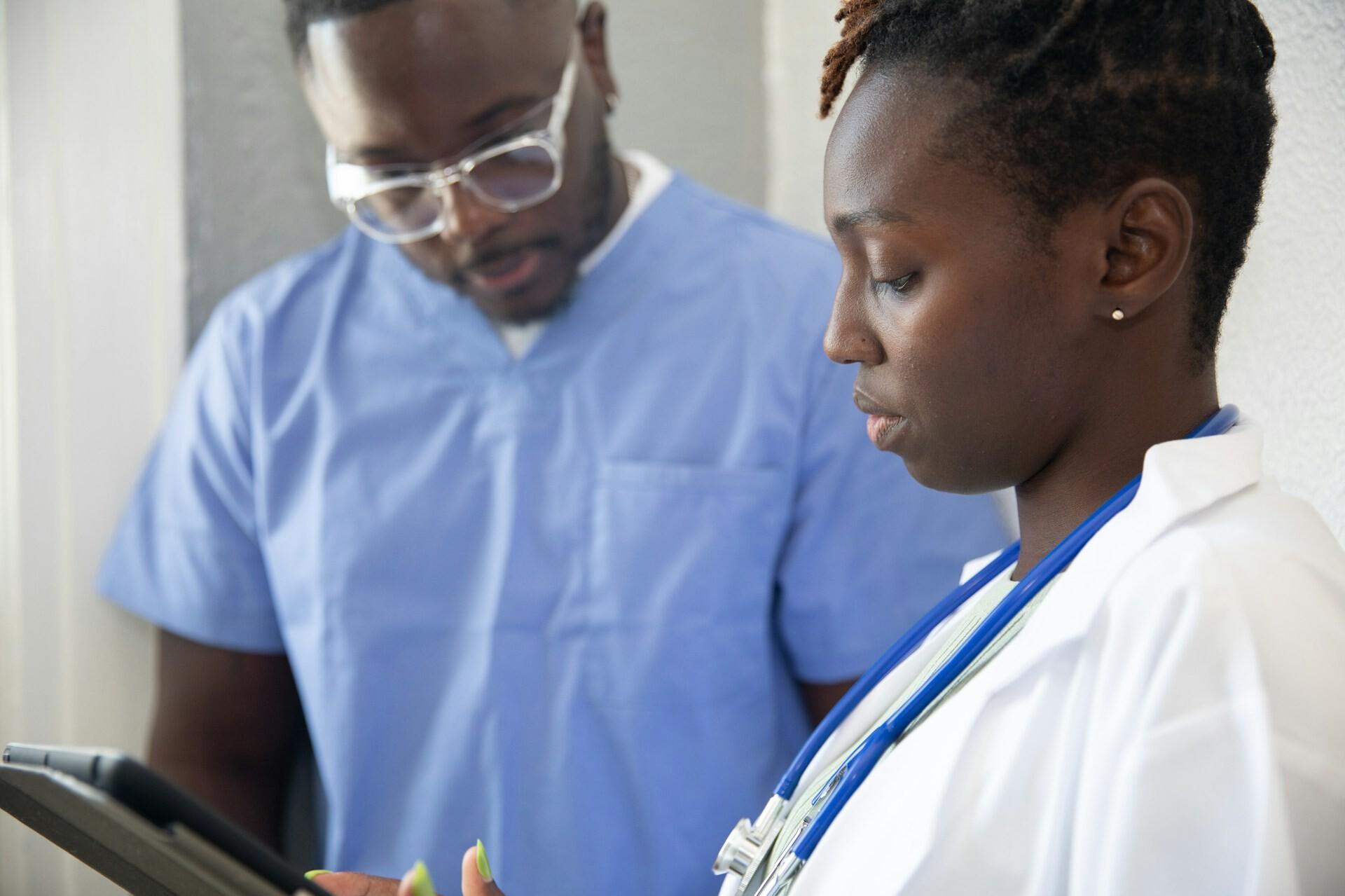 Ärztliche Besprechung A doctor and a nurse are looking at a tablet together