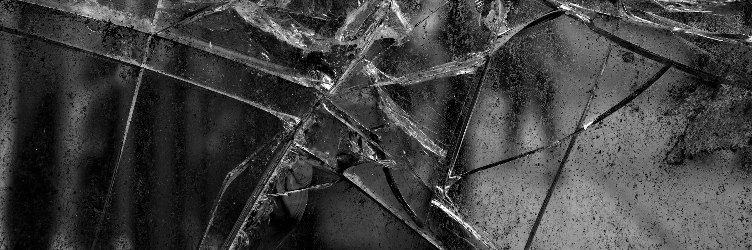 Gebrochenes Fenster In einer Fensterscheibe zeigen sich Risse