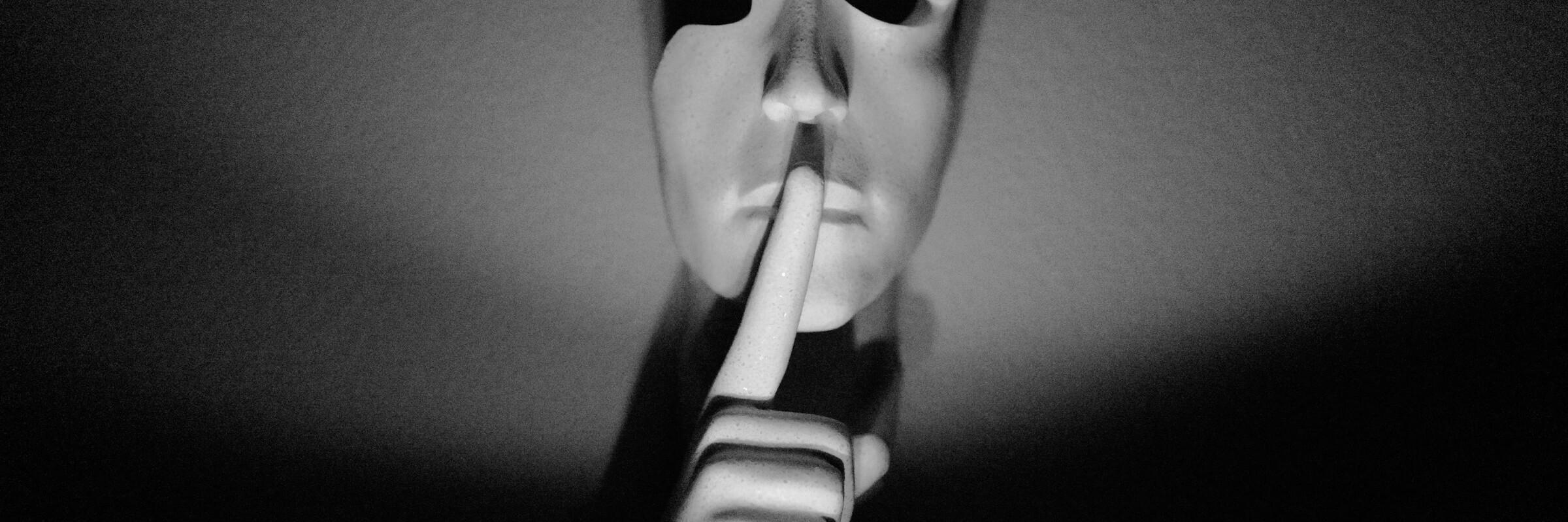 Geheimnis Eine Maske hält den Finger vor ihren Mund