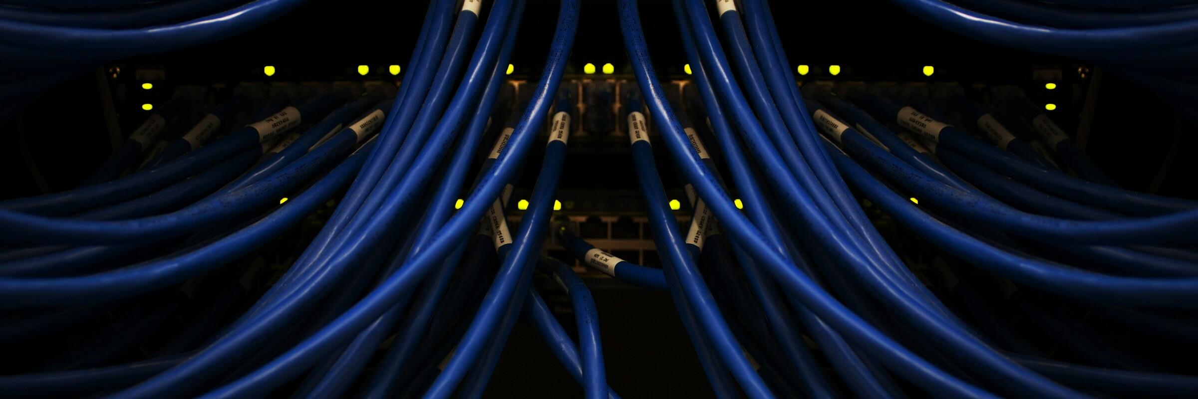 Kabel Mehrere blaue Kabel, im Hintergrund kleine gelbe Lichter