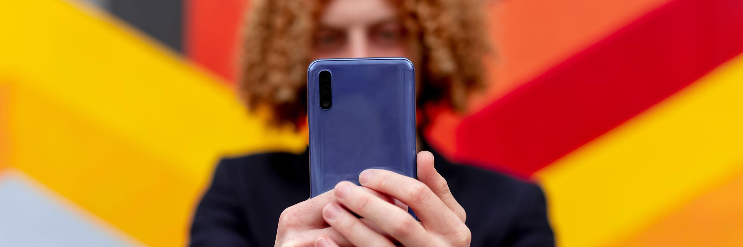 Handy Person richtet ihr Handy in die Kamera