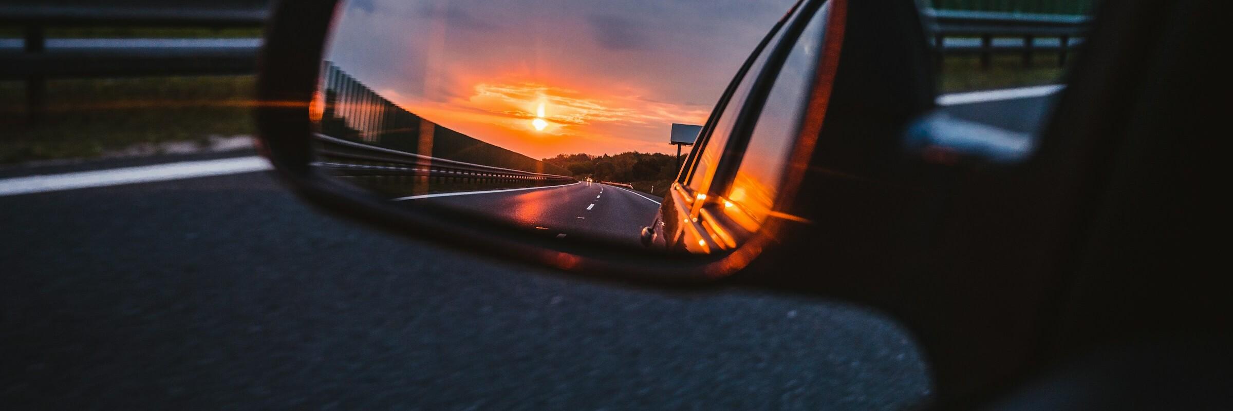 Sonnenuntergang Im Seitenspiegel eines Autos spiegelt sich der Sonnenuntergang