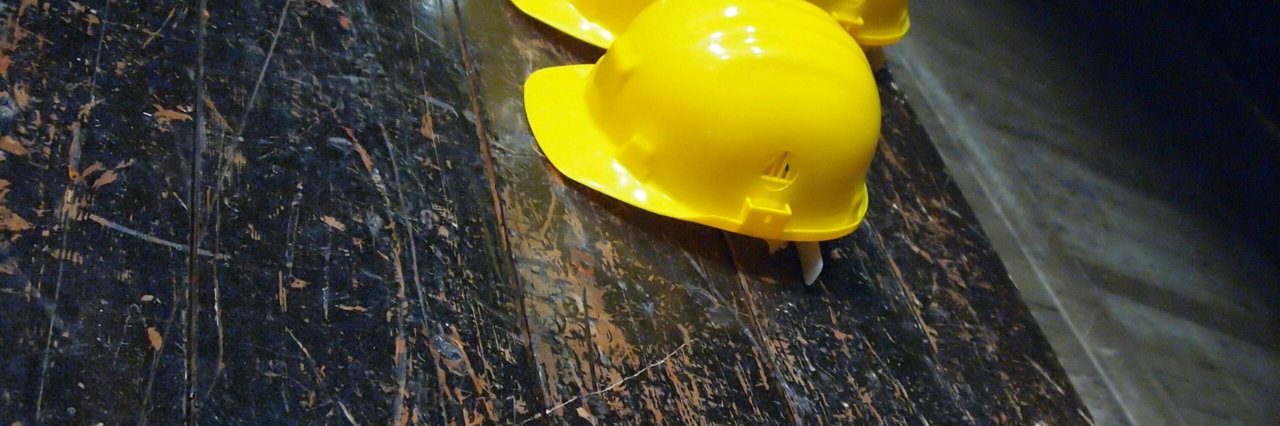 Sicherheitshelm A yellow safety helmet is lying on dark wood