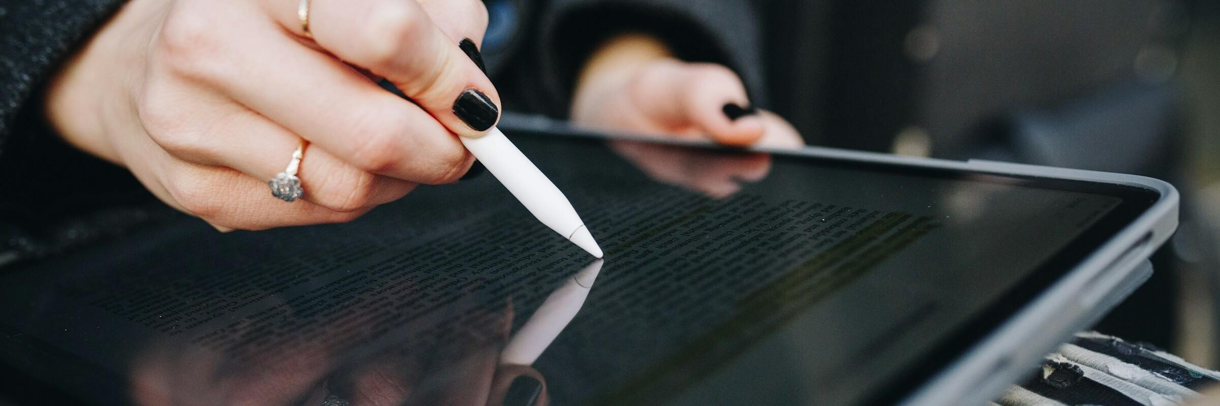 Hand einer Frau prüft einen digitalen Vertrag auf einem Tablet
