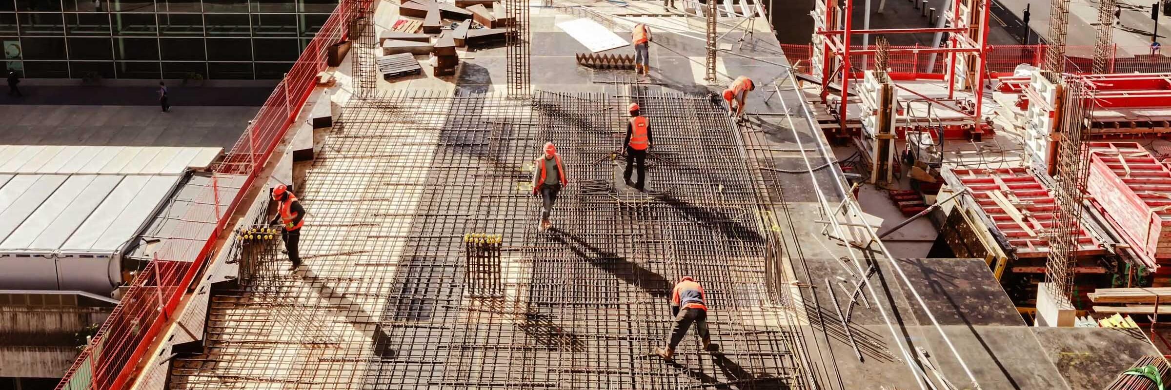 Baustelle Blick von oben auf eine Baustelle, auf der Bauarbeiter umher gehen