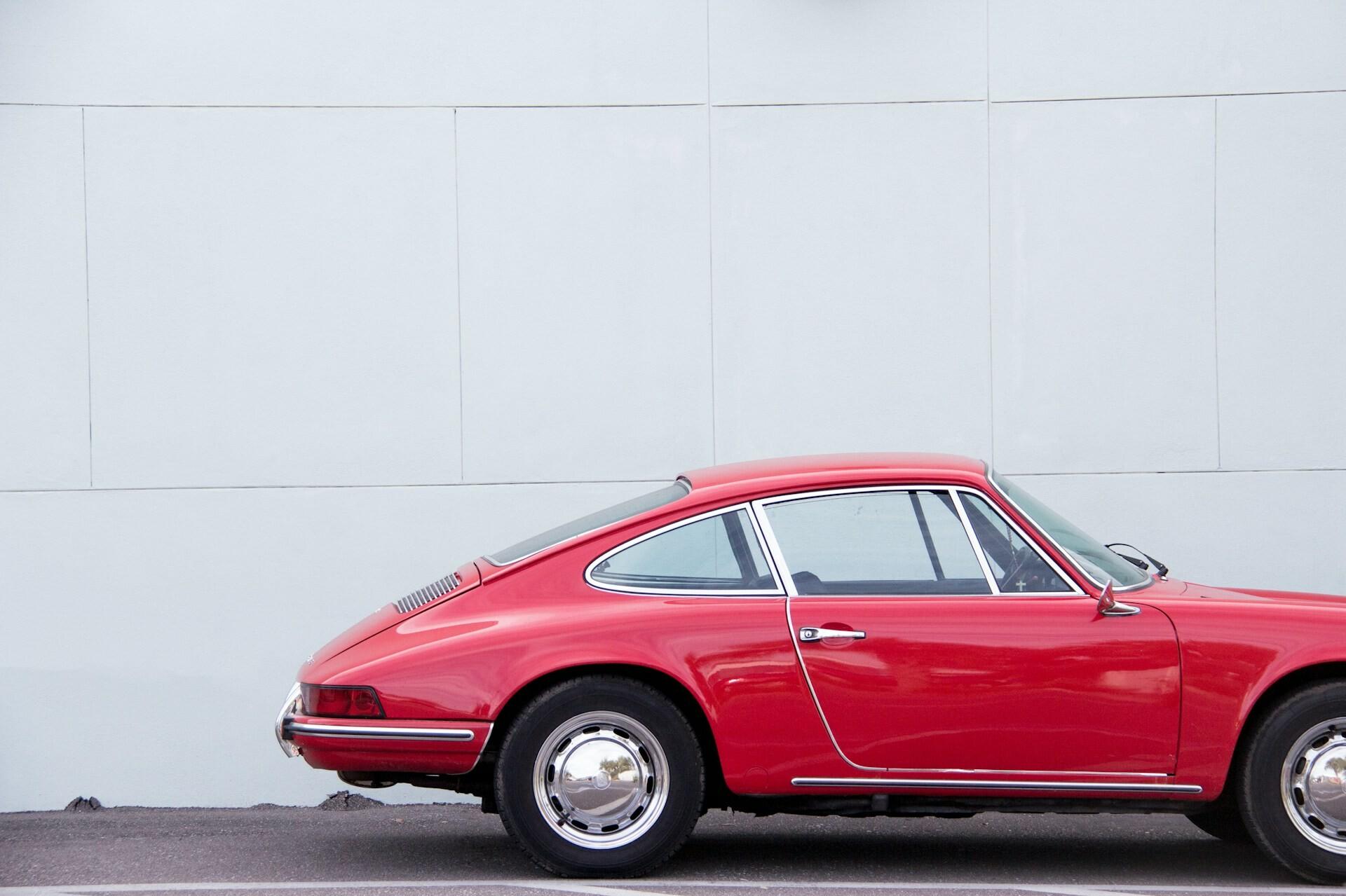 Rotes Coupé Rotes Coupé vor einer weißen Wand